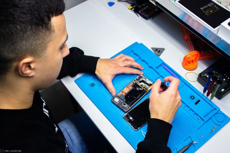 Ein Mitarbeiter repariert ein Handy bei einem Display-bruch